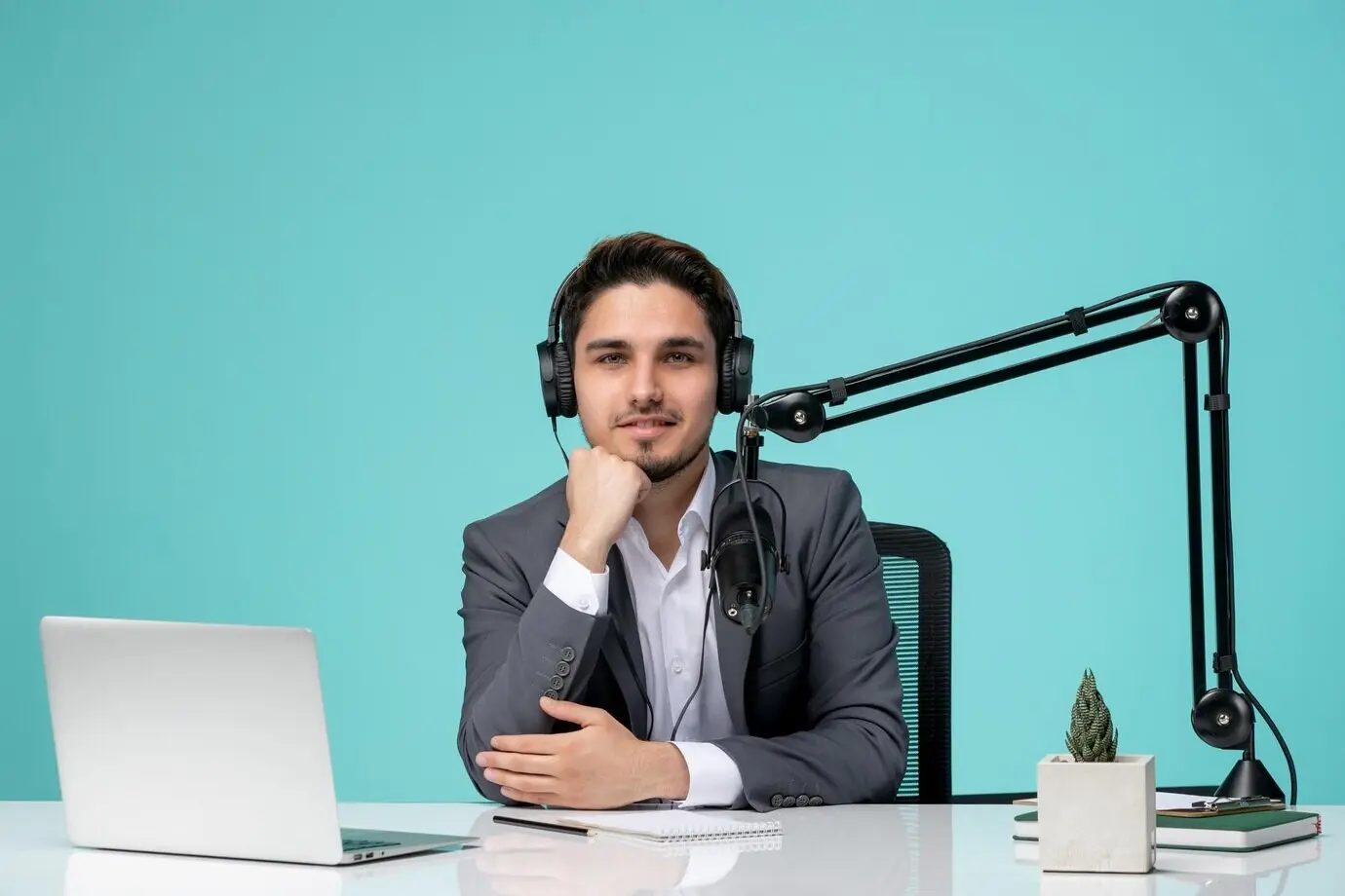 Блогер-журналист — симпатичный, милый, красивый парень в сером костюме, записывает видео и улыбается.